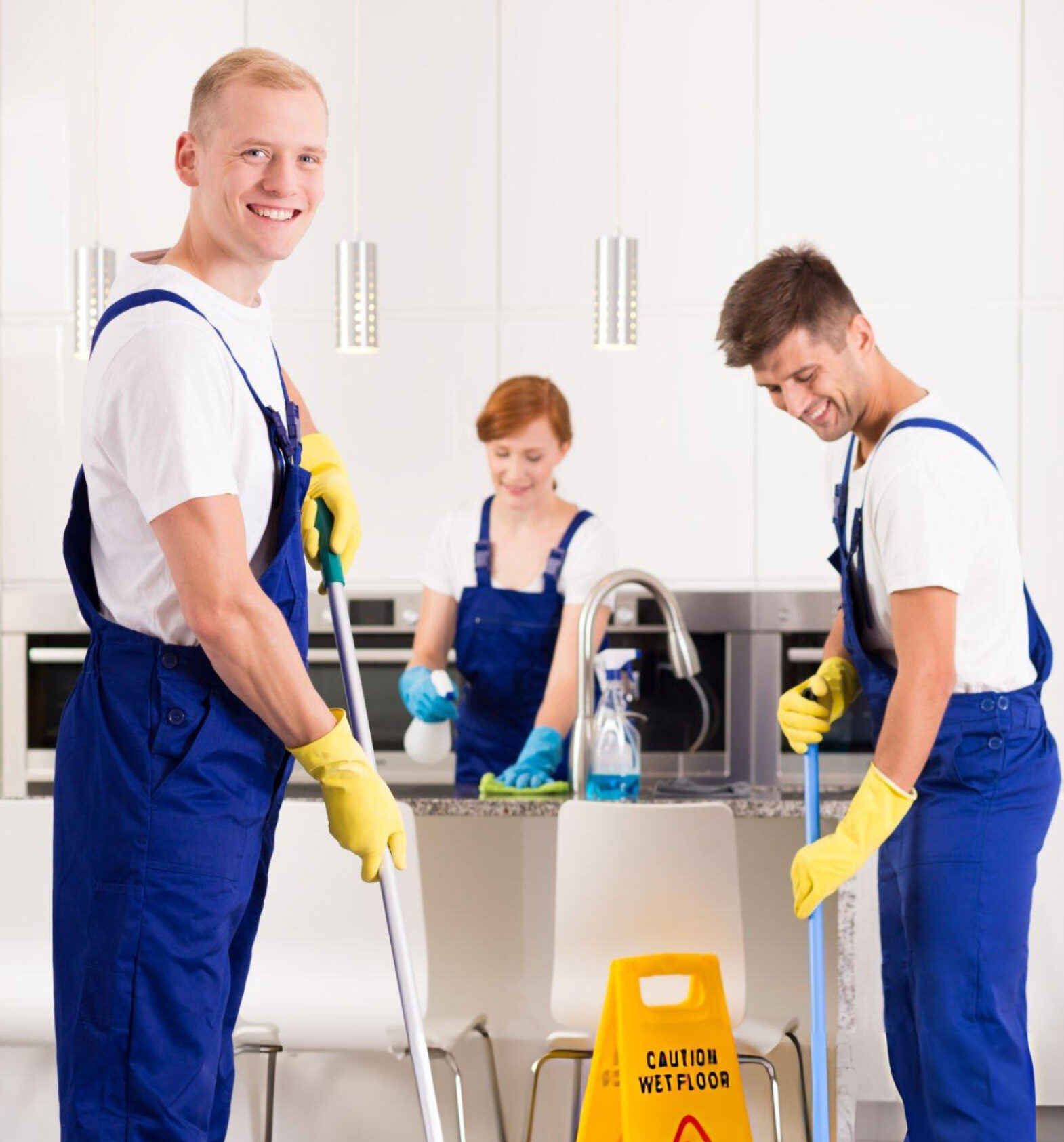 Three men in overalls thoroughly cleaning a kitchen, illustrating reliable cleaning expertise in Brisbane.